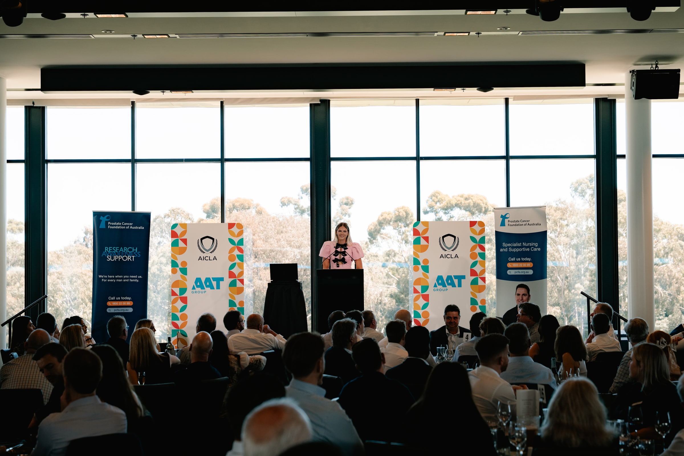 Shayna Jack delivering a keynote from a lectern to a full conference room.